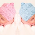 foto de 2 bebes, um com boina azul e o outro com rosa