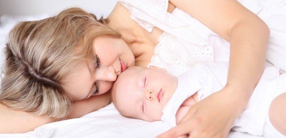 foto de uma mulher na cama com um bebe