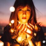 Uma mulher com as mãos juntas simulando segurando os átomos